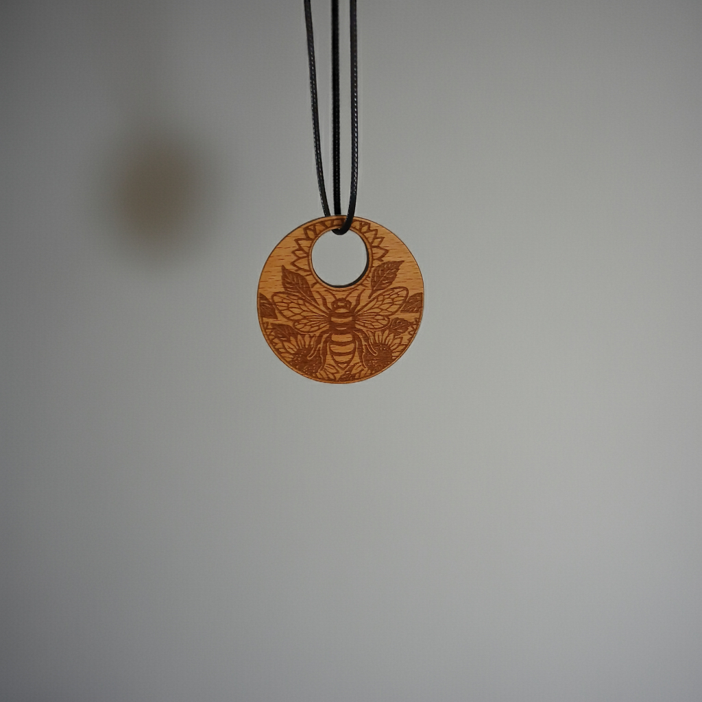 Wood Pendant with a Bee and Floral engraving, with waxed necklace. Pendant measures 50mm diameter