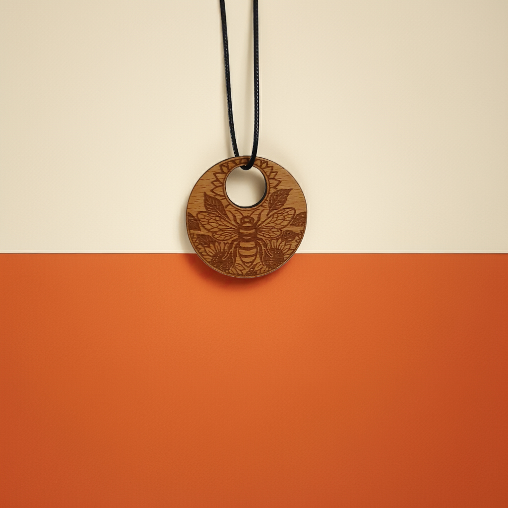 Wood Pendant with a Bee and Floral engraving, with waxed necklace. Pendant measures 50mm diameter